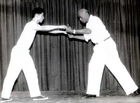 Mestre Bimba ensinado um aluno pelas mãos